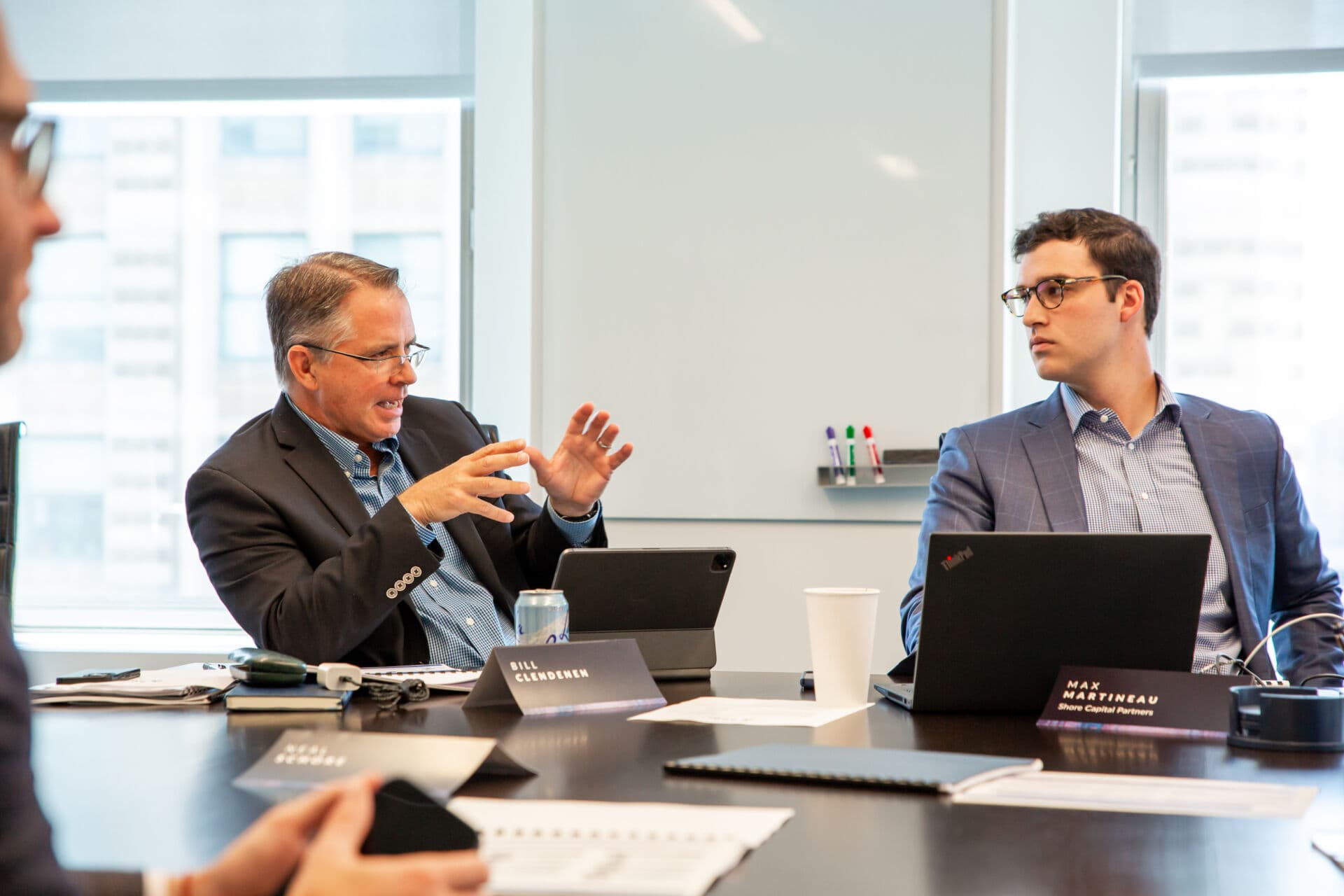 Bill Clendenen and Max Martineau in conversation at meeting in conference room