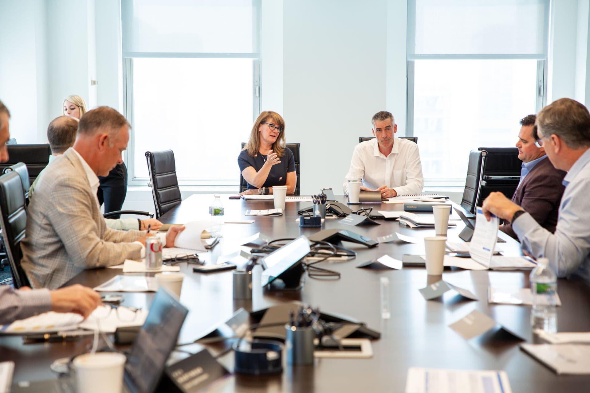 Executives seated around conference room table